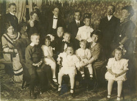 Bildet er tatt i Kirkegaten 22, fra venstre Ludvig, 
søsteren til Grethe, Herman, Bostrøm, Ingulf, Jens og Elisabeth. Fra v. Søsteren til Trina, Grethe, Bent? Eivind, Sofia, Sophie, Kjell, Pedro, Erik, Trina 
og Sally tatt i 1911.